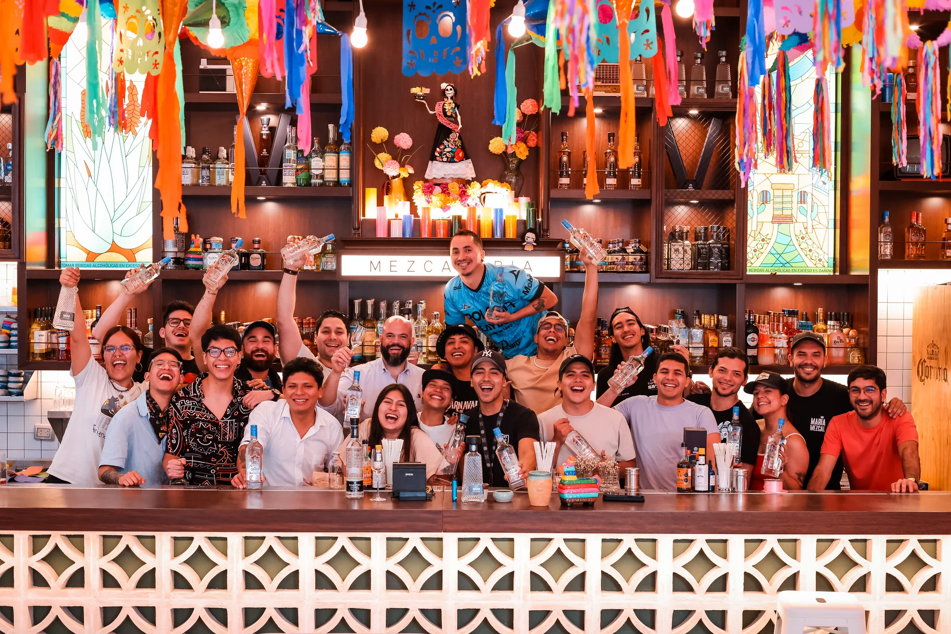 Equipo María Mezcal en la barra celebrando